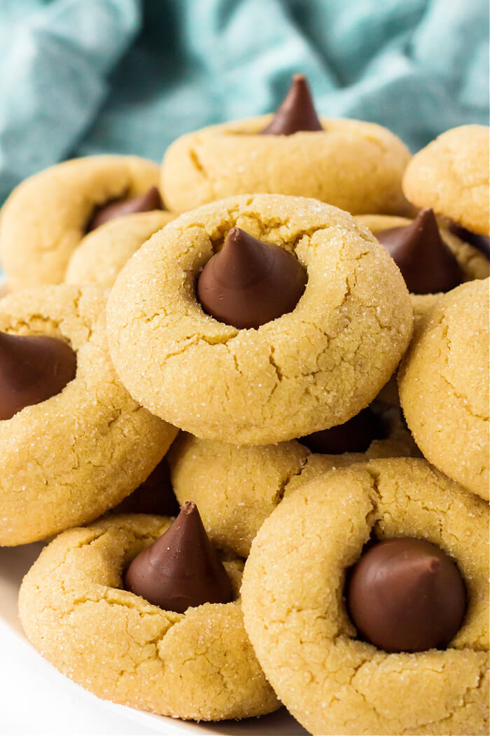Peanut Butter Blossoms (Hershey Kiss Cookies) are pillowy soft peanut butter cookies rolled in sugar & topped with a Hershey's Kiss. EASY HOMEMADE PEANUT BUTTER BLOSSOMS