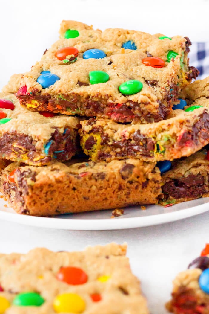 Monster cookie bars are ooey gooey peanut butter, oatmeal, and M&M filled dessert bars that are bound to put a smile on your face! EASY MONSTER COOKIE BAR RECIPE