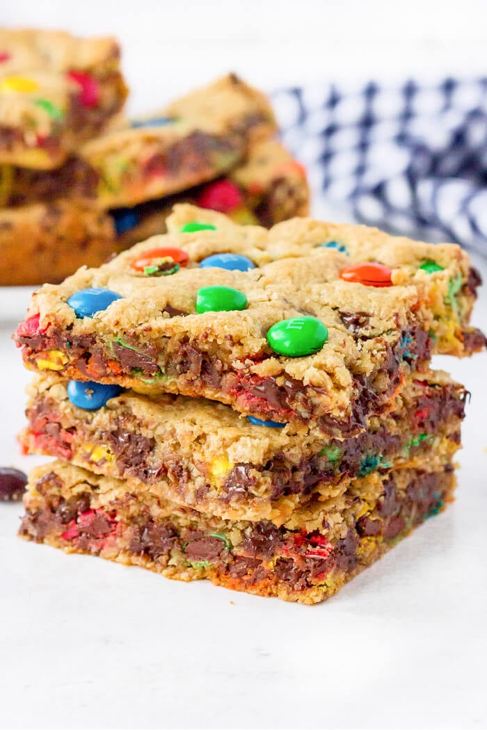 Monster cookie bars are ooey gooey peanut butter, oatmeal, and M&M filled dessert bars that are bound to put a smile on your face! PEANUT BUTTER OATMEAL MONSTER COOKIE BARS