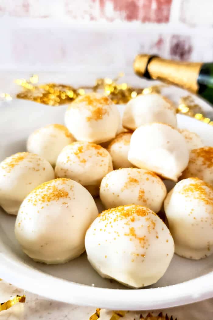 Champagne truffles are a decadent dessert made with white chocolate, cream and champagne topped with gold sprinkles for extra fancy flair! CHAMPAGNE TRUFFLES