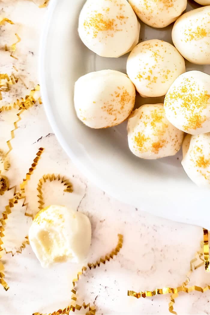Champagne truffles are a decadent dessert made with white chocolate, cream and champagne topped with gold sprinkles for extra fancy flair! CHAMPAGNE TRUFFLES RECIPE