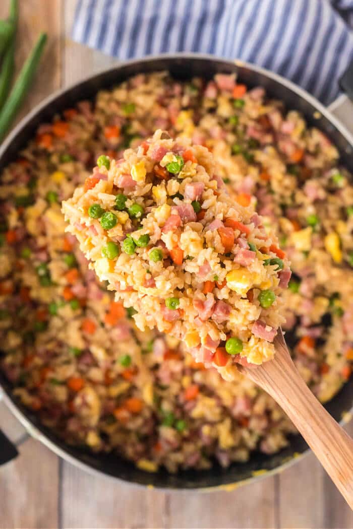 Ham fried rice is a flavorful and simple dish made with ham, peas, carrots, seasoned rice, and eggs topped for an easy weeknight meal! FRIED RICE WITH HAM