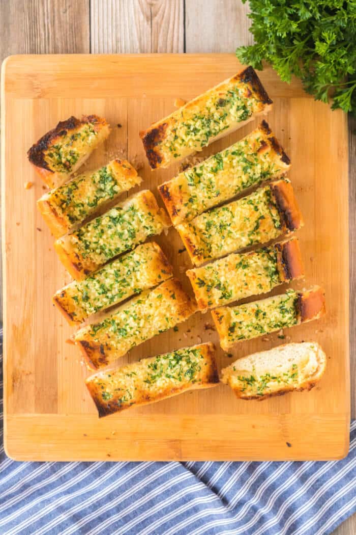 Garlic bread made with fresh bread and loaded with butter, garlic cloves and fresh chopped parsley is the perfect addition to any meal! GARLIC BREAD RECIPE