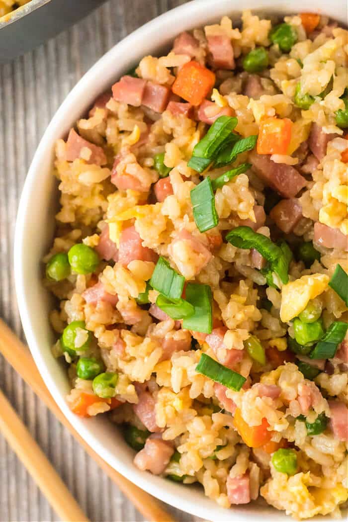 Ham fried rice is a flavorful and simple dish made with ham, peas, carrots, seasoned rice, and eggs topped for an easy weeknight meal! HAM FRIED RICE RECIPE