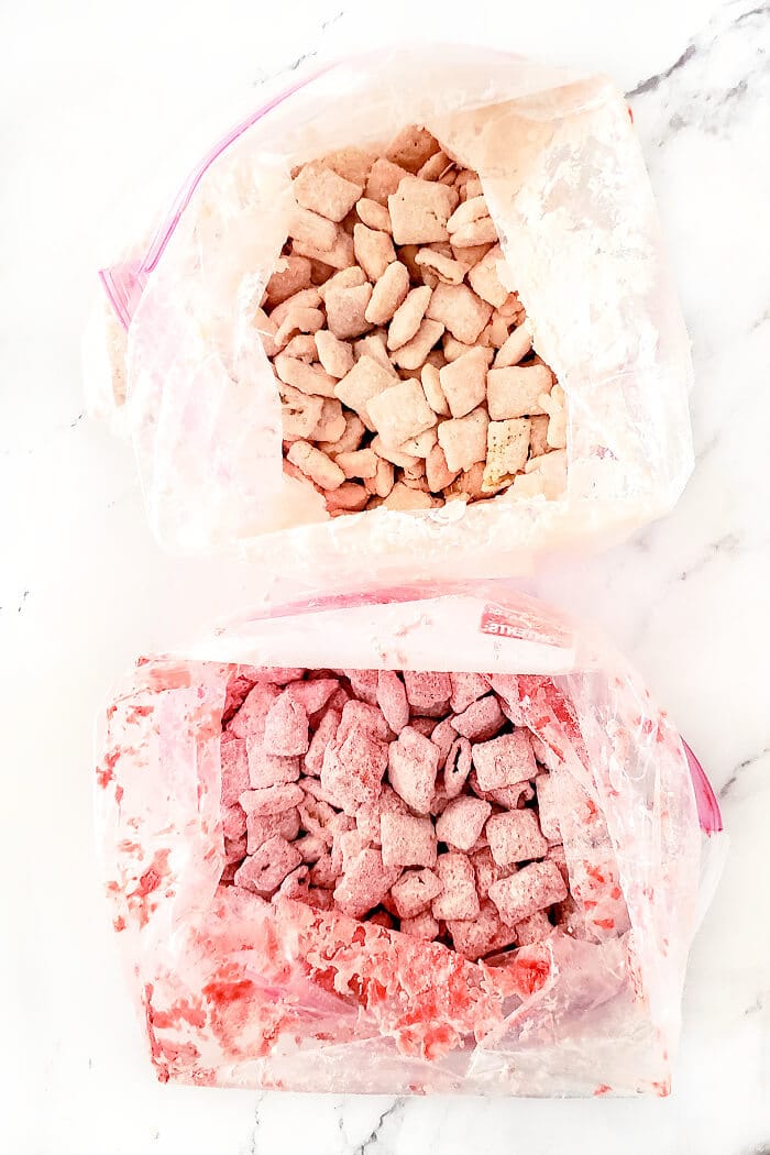 Strawberry muddy buddies are a delicious snack made with Chex, white and red chocolate melts, strawberry cake mix, powdered sugar and M&MS. HOW TO MAKE PINK MUDDY BUDDIES
