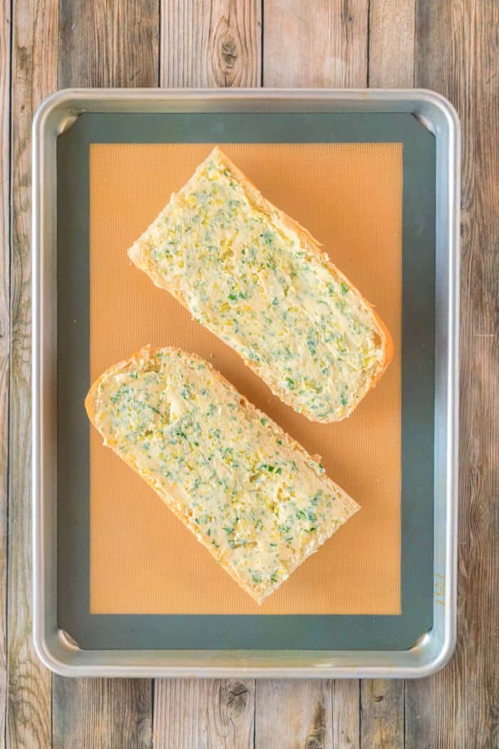 Garlic bread made with fresh bread and loaded with butter, garlic cloves and fresh chopped parsley is the perfect addition to any meal! RECIPE FOR HOMEMADE GARLIC BREAD