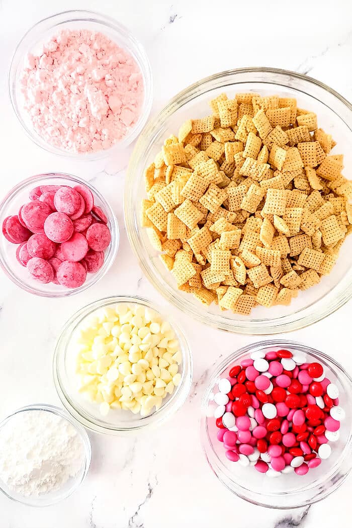 Strawberry muddy buddies are a delicious snack made with Chex, white and red chocolate melts, strawberry cake mix, powdered sugar and M&MS. STRAWBERRY MUDDY BUDDIES INGREDIENTS