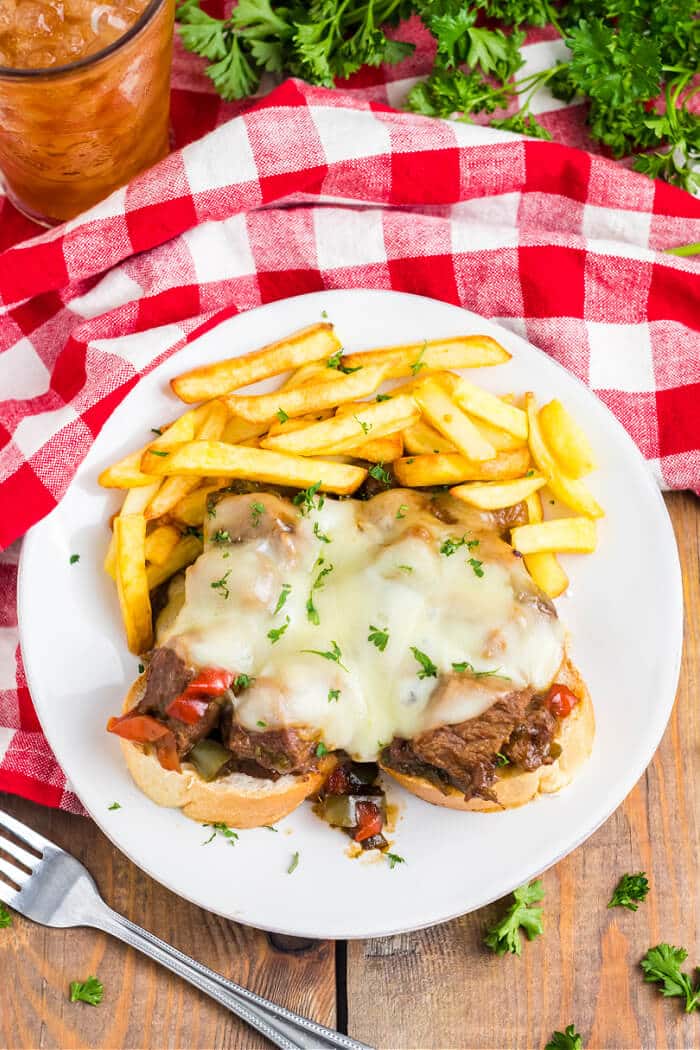 Slow cooker Philly cheesesteaks are a simple and delicious dump and go meal made with beef, peppers, onions, au jus mix, & provolone cheese. SLOW COOKER CHEESESTEAKS