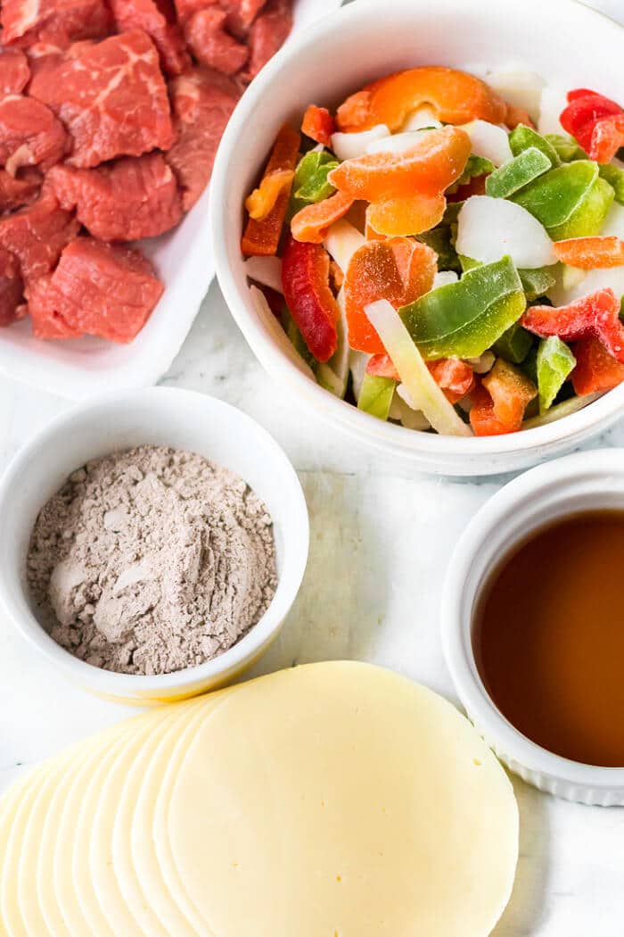 Slow cooker Philly cheesesteaks are a simple and delicious dump and go meal made with beef, peppers, onions, au jus mix, & provolone cheese. SLOW COOKER PHILLY CHEESESTEAK INGREDIENTS