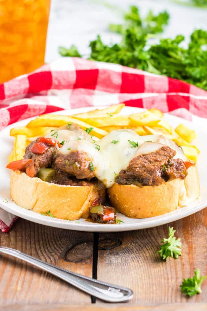 Slow cooker Philly cheesesteaks are a simple and delicious dump and go meal made with beef, peppers, onions, au jus mix, & provolone cheese. SLOW COOKER PHILLY CHEESESTEAK RECIPE