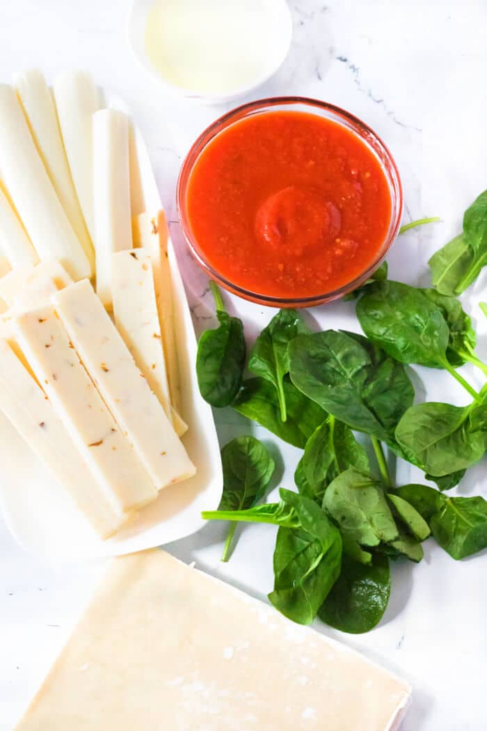 Air fryer spinach mozzarella sticks are an easy recipe made with egg roll wrappers, string cheese and baby spinach for crispy cheese sticks! AIR FRYER MOZZARELLA STICKS INGREDIENTS