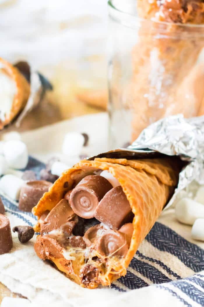 Campfire cones are a fun treat to make for your next get together made with waffle cones, mini marshmallows, and chocolate candy. CAMPFIRE SMORE CONES