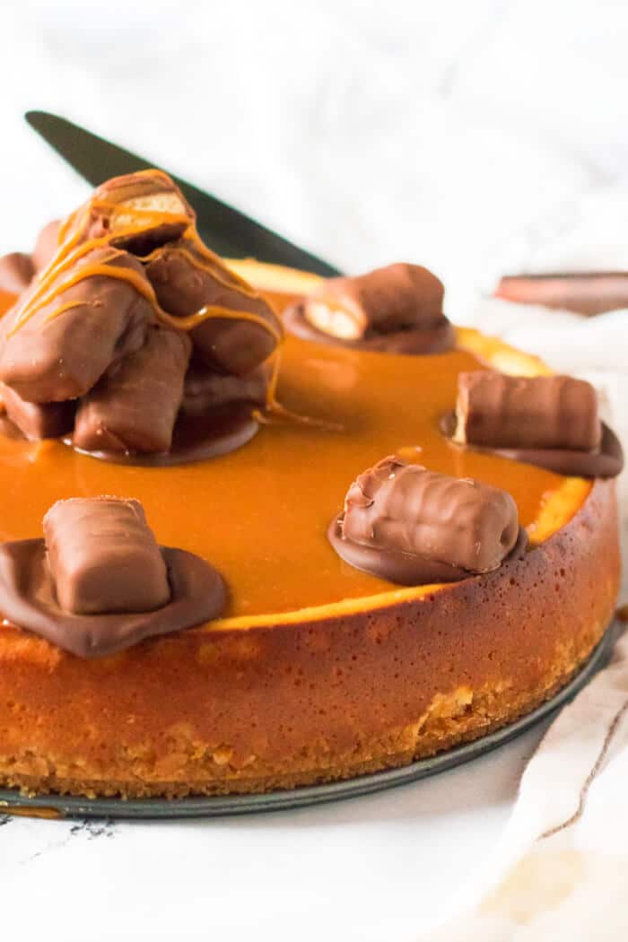 Twix cheesecake is a delightful dessert made with a cookie crust and homemade cheesecake topped with caramel, chocolate and of course, Twix! CARAMEL TWIX CHEESECAKE