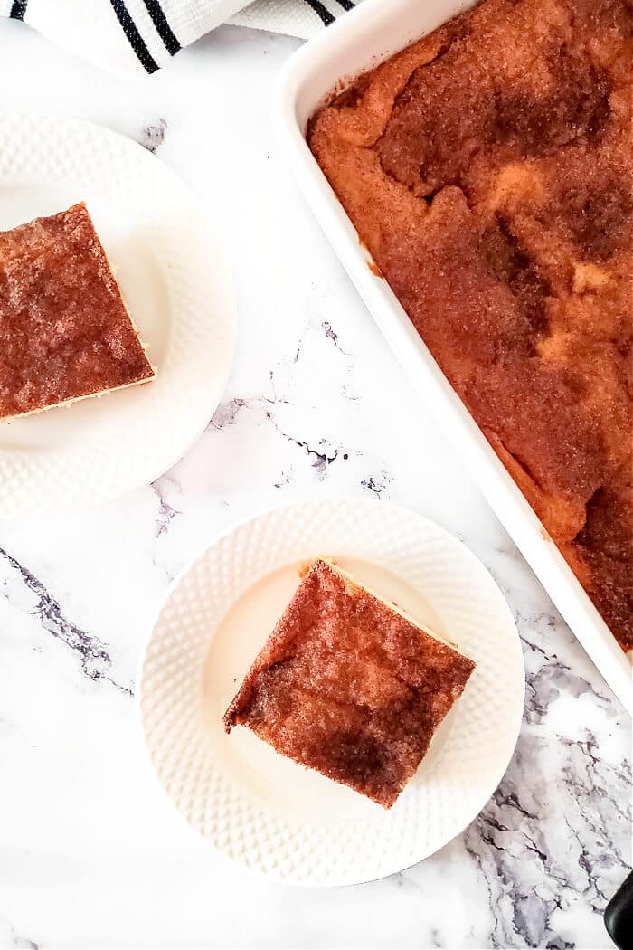 Churro cheesecake bars are a delicious homemade cheesecake layered between crescent rolls and topped with a burst of cinnamon sugar flavor! CHEESECAKE CHURRO BARS
