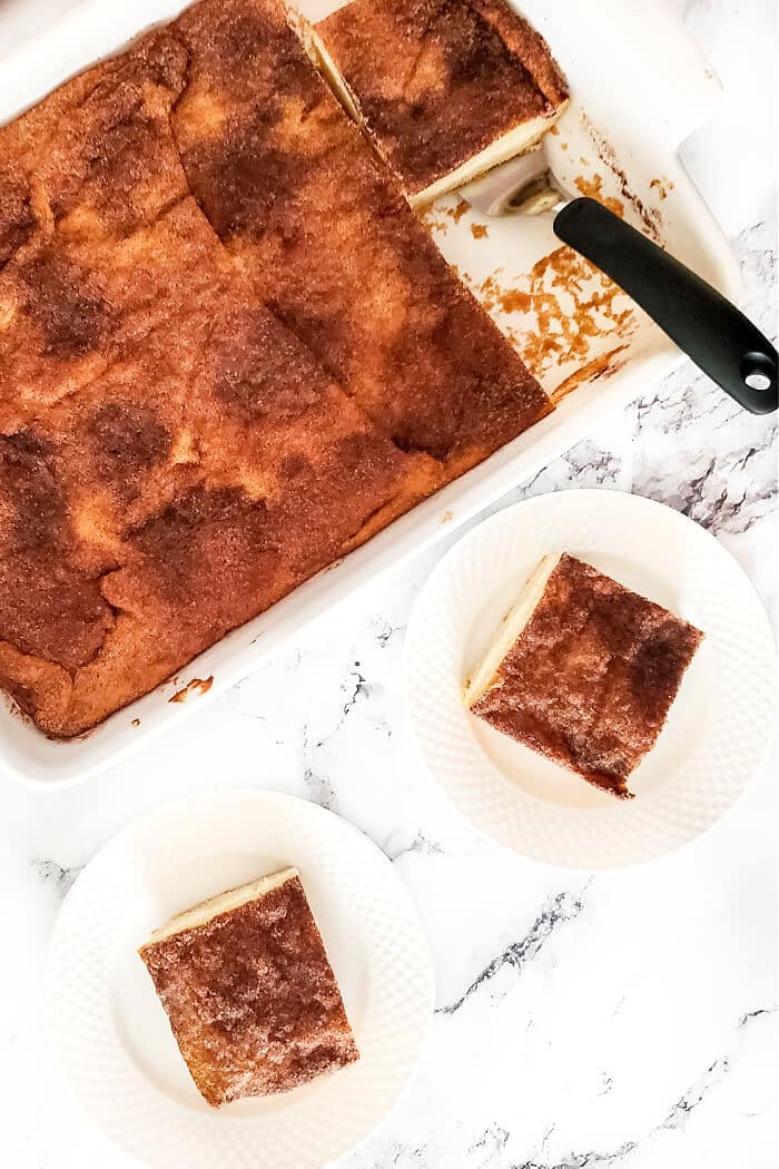Churro cheesecake bars are a delicious homemade cheesecake layered between crescent rolls and topped with a burst of cinnamon sugar flavor! CHURRO CHEESECAKE BARS RECIPE