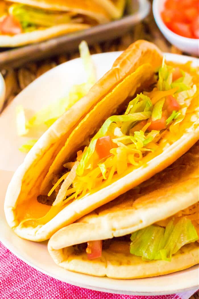 Cheesy Gordita crunch is a crunchy taco with a hard shell wrapped in a pita stuffed with beef, spicy ranch, lettuce, tomato, & more cheese! GORDITA CRUNCH RECIPE