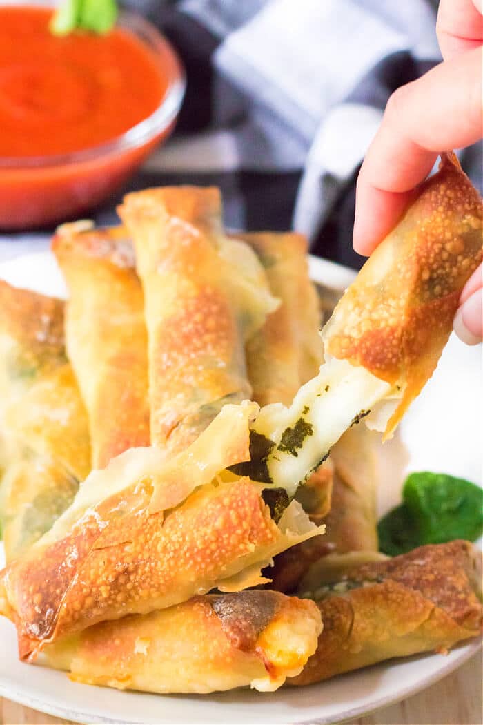 Air fryer spinach mozzarella sticks are an easy recipe made with egg roll wrappers, string cheese and baby spinach for crispy cheese sticks! MOZZARELLA STICKS AIR FRYER